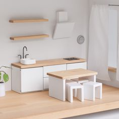 a white kitchen with wooden counter tops and shelves next to a potted green plant