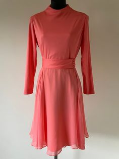 Late 1960s 'Tegler's Inc. Buffalo' Coral Party Dress. Fully lined. Poly bodice with high neck and long sleeves. Matching material belt attached at waist, with 4 buttons at side. Dreamy silk chiffon skirt.  Back zipper. Measurements: Bust: 34" Waist: 26" Hips: Up to 40" Length: 38" Excellent, vintage condition. 2 small pulls on back bodice. 2 tiny pinholes in chiffon skirt. Barely visible, does not affect wear. Mid-century Long Sleeve Fitted Dress, Fitted Mid-century Long Sleeve Dresses, Retro Long Sleeve Evening Dress, Retro Long Sleeve Cocktail Dress, Vintage Belted Evening Dress, Coral Party, Blue Wedding Guest Dresses, Coral Outfit, Chiffon Skirt