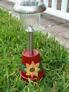 a red and green solar powered light in the grass