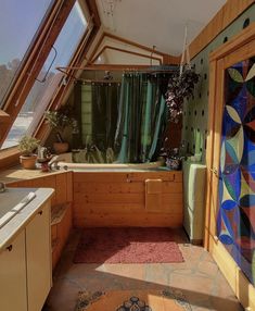 a bathroom with a bathtub, sink and rugs on the floor in front of an open window