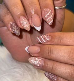 This festive manicure combines classic French tips with holiday accents. Soft nude nails are elevated with white snowflakes, glittery pink polish, and wavy lines for a delicate, wintry touch. The blend of almond-shaped nails and glitter enhances the chic holiday spirit, making it a perfect choice for those who love subtle elegance with a festive twist. Red White And Silver Christmas Nails, Glittery Christmas Nails Sparkle, Pink Glitter Christmas Nails, Christmas Nails Subtle, Nail Glitter Ideas, Cute Pink Christmas Nails, Soft Nude Nails, Rose Gold Christmas Nails, Winter Nail Designs Short