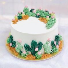 a white cake with green and pink decorations