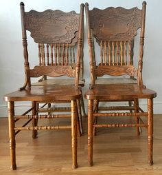 two wooden chairs sitting on top of a hard wood floor