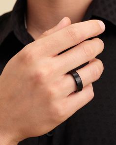 a man wearing a black ring with a diamond in it