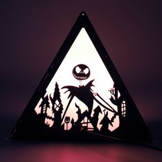 a triangle shaped lamp with a jack skellingy face on it