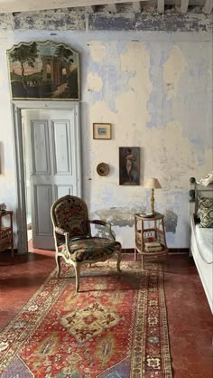 an old fashioned living room with antique furniture and paintings on the walls, along with a large rug