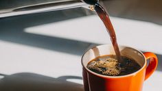 a cup of coffee being poured into it