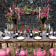 the table is set up with pink chairs and place settings for two people to sit at