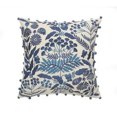 a blue and white pillow with pom poms