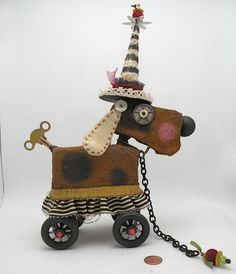 a dog with a hat on top of it's head is pulling a toy carriage