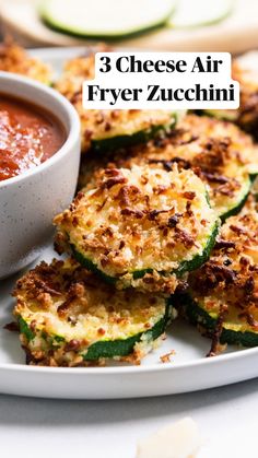 zucchini fritters on a white plate with sauce in a bowl next to them