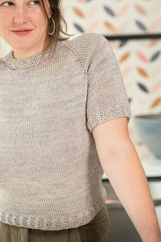 a woman standing in front of a counter top with a pizza on it's side