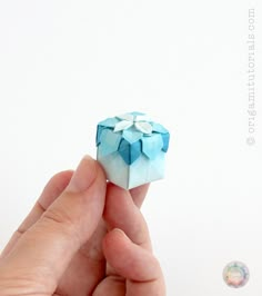 a hand holding an origami piece in it's palm