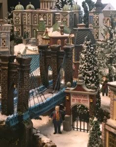 a model of a city with snow on the ground and people standing in front of it