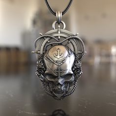 Embark on a maritime adventure with our Sea Skull Steering Wheel 925 Sterling Silver Necklace. This piece is a captivating blend of nautical charm and gothic allure, capturing the essence of the mysterious deep blue and its legends. Expertly crafted from premium 925 sterling silver, the necklace features a detailed pendant combining a skull and a ship's steering wheel, symbolizing the unpredictable nature of the sea and the mysteries it holds. Its intricate design ensures it stands out, making i Silver Anchor-shaped Metal Jewelry, Nautical Style Metal Jewelry Gift, Silver Anchor Shaped Metal Jewelry, Silver Anchor-shaped Jewelry In Metal, Symbolic Silver Anchor Jewelry, Silver Necklace With Engraved Anchor Pendant, Silver Anchor-shaped Nautical Jewelry, Silver Nautical Anchor Jewelry, Nautical Style Silver Anchor Jewelry