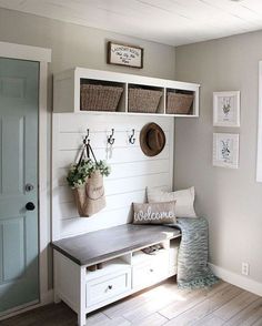 a white bench with baskets on it next to a door