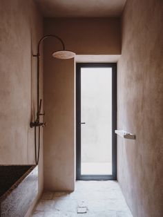 an open door leading into a bathroom next to a bathtub and shower head on the wall