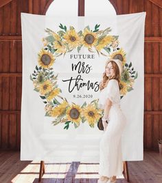 a woman standing in front of a white banner with sunflowers and the words, future mrs thomas