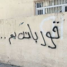 graffiti is spray painted on the side of a building in an arabic language that reads,