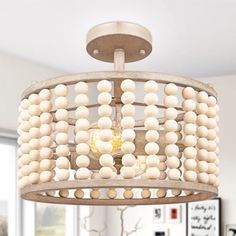 a wooden chandelier hanging from the ceiling in a living room with white walls