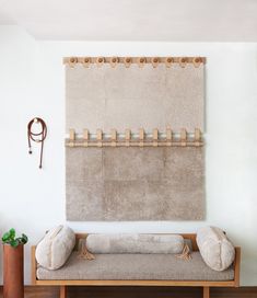 a room with a couch, rug and coat rack on the wall in front of it