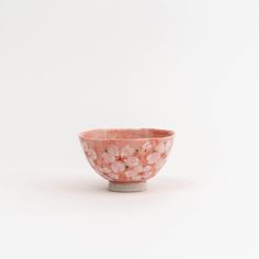 a pink flowered bowl sitting on top of a white table