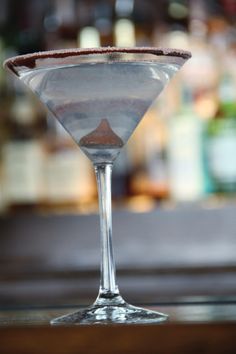 a martini glass sitting on top of a wooden table