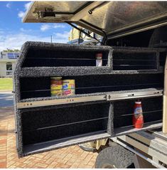 the back end of a truck with food in it's cargo compartment and two cans of juice