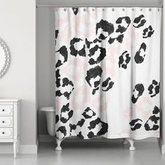 a black and white shower curtain with an animal print on it, in a bathroom