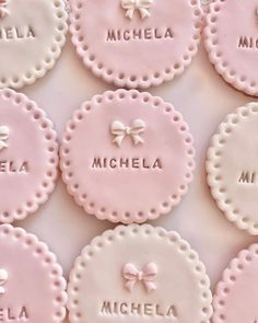 pink and white cookies with names on them for a baby's first birthday party