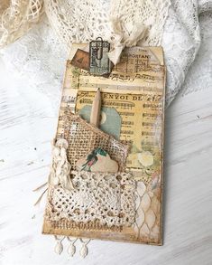 an altered book with lace and crochet on it sitting on top of a table