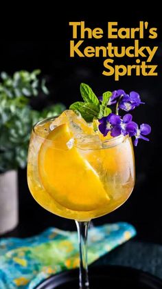 a close up of a drink in a glass on a plate with flowers and leaves