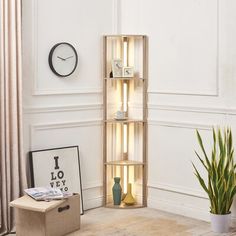 a living room with a clock on the wall next to a plant in a vase