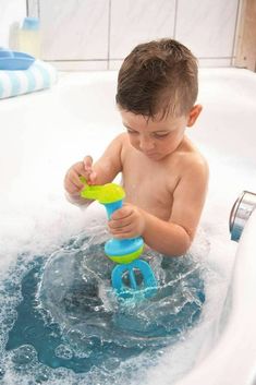 a young boy playing in a bathtub with toys