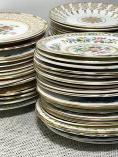 a stack of plates sitting next to each other on top of a cloth covered table