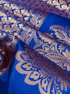 Gorgeous Statement designer Saree in Royal Blue color with Muted Gold Zari Weaving. Saree has Floral Motifs all over with design pattern borders with big flower buttas. Item : SareeColor : Royal Blue Base Fabric : Banarasi Silk Blouse material : Soft Banarasi Silk Work : Handloom Bollywood Blue Sets With Zari Weaving, Blue Zari Weaving Choli For Eid, Blue Choli With Zari Weaving For Eid, Blue Saree Set For Puja, Royal Blue Traditional Wear For Puja And Diwali, Royal Blue Traditional Drape For Puja, Royal Blue Traditional Wear For Puja, Festive Royal Blue Traditional Wear With Self Design, Blue Banarasi Silk Sets With Zari Weaving