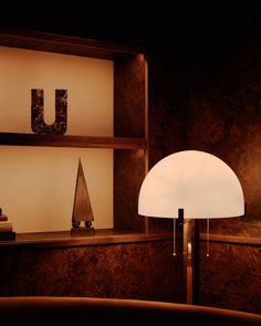 a lamp sitting on top of a wooden table next to a shelf filled with books