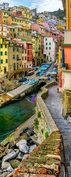 colorful buildings line the side of a river in rio, italy with cars parked on both sides