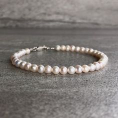 This freshwater pearl bracelet is the perfect wedding accessory. The minimalist design allows the beauty of the pearls to be the focus. At checkout, choose a gold or sterling silver clasp for your bracelet. * METAPHYSICAL PROPERTIES OF PEARLS * peace prosperity feminine energy integrity wisdom faith Free gift with every crystal jewelry purchase from Gems by Kelley: a beautiful card with the metaphysical properties of each crystal in your order. Would you like to see more freshwater pearl jewelry Minimalist Wedding Jewelry, Modern Pearl Jewelry, Gold Stretch Bracelet, Bracelets Etsy, Pearl Bracelets, Freshwater Pearl Jewelry, June Birthstone Jewelry, Freshwater Pearl Bracelet, June Birthstone