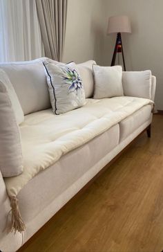 a white couch sitting on top of a hard wood floor