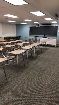 an empty classroom with desks and chairs