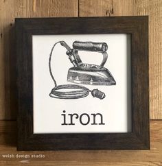 an iron framed in a wooden frame with the word iron printed on it's side