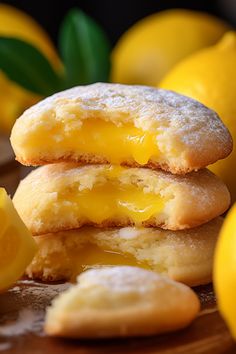 three lemon cookies stacked on top of each other next to some lemons and leaves