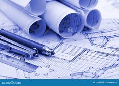 some blueprints and pencils are laying on top of each other in this image