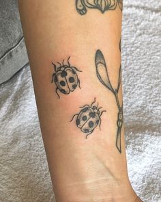 a lady bug tattoo on the foot of a woman's right leg and spoon