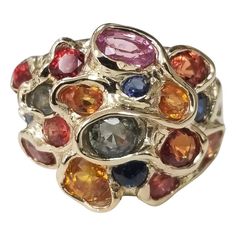 14 karat multicolored sapphire cluster ring, containing 25 round sapphires (orange, yellow, blue, green and lavender) of very fine gem quality weighing 6.43cts. This ring is a size 7 but we will size to fit for free. Luxury Multi-stone Classic Sapphire Ring, Luxury Elegant Cluster Gemstones, Luxury Multi-stone Gold-toned Gemstones, Luxury Multicolor Round Gemstones, Luxury Multicolor Jewels Gemstones, Luxury 22k Gold Multicolor Jewelry, Multicolor Sapphire Multi-stone Ring, Multicolor Multi-stone Sapphire Ring, Multicolor Sapphire Ring In Fine Jewelry Style