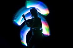 a woman standing in front of a colorful light