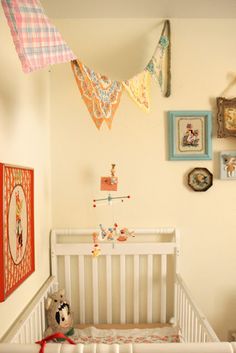 a baby crib in a room with pictures on the wall