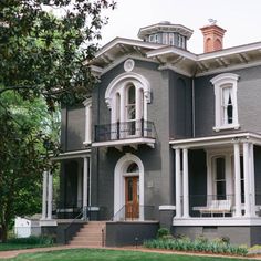 a large gray house with white trim and windows