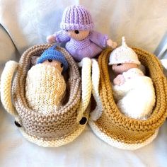 three knitted nativity items sitting on top of a white blanket with two baby sheeps in the middle